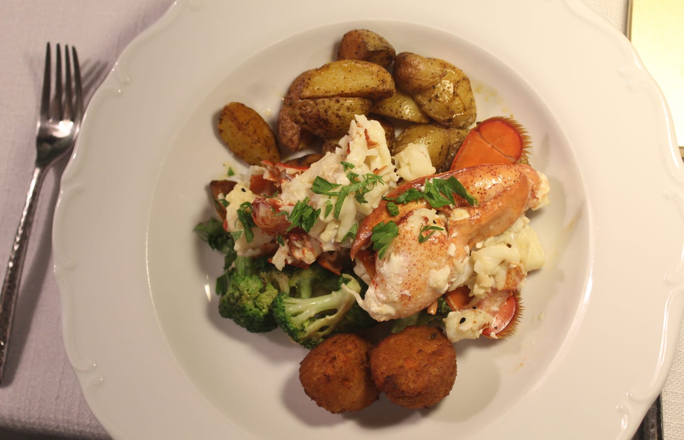 Lobster and roasted vegetables on a white plate